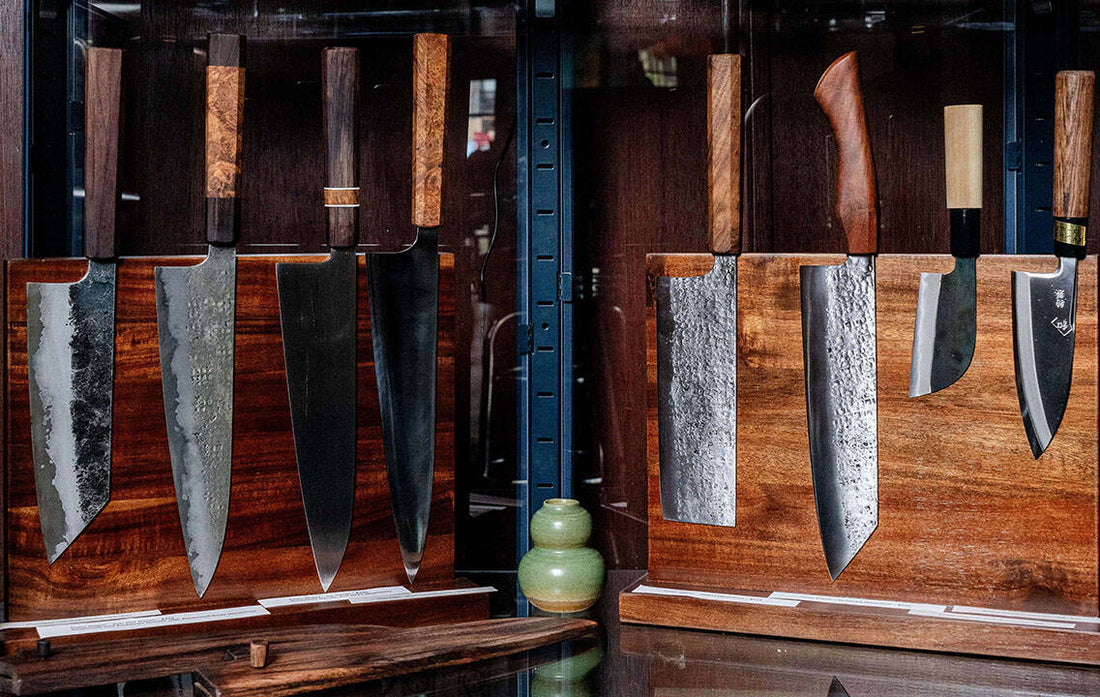 Different styles of Japanese chef knives for sale, stored on a magnet board in a display case