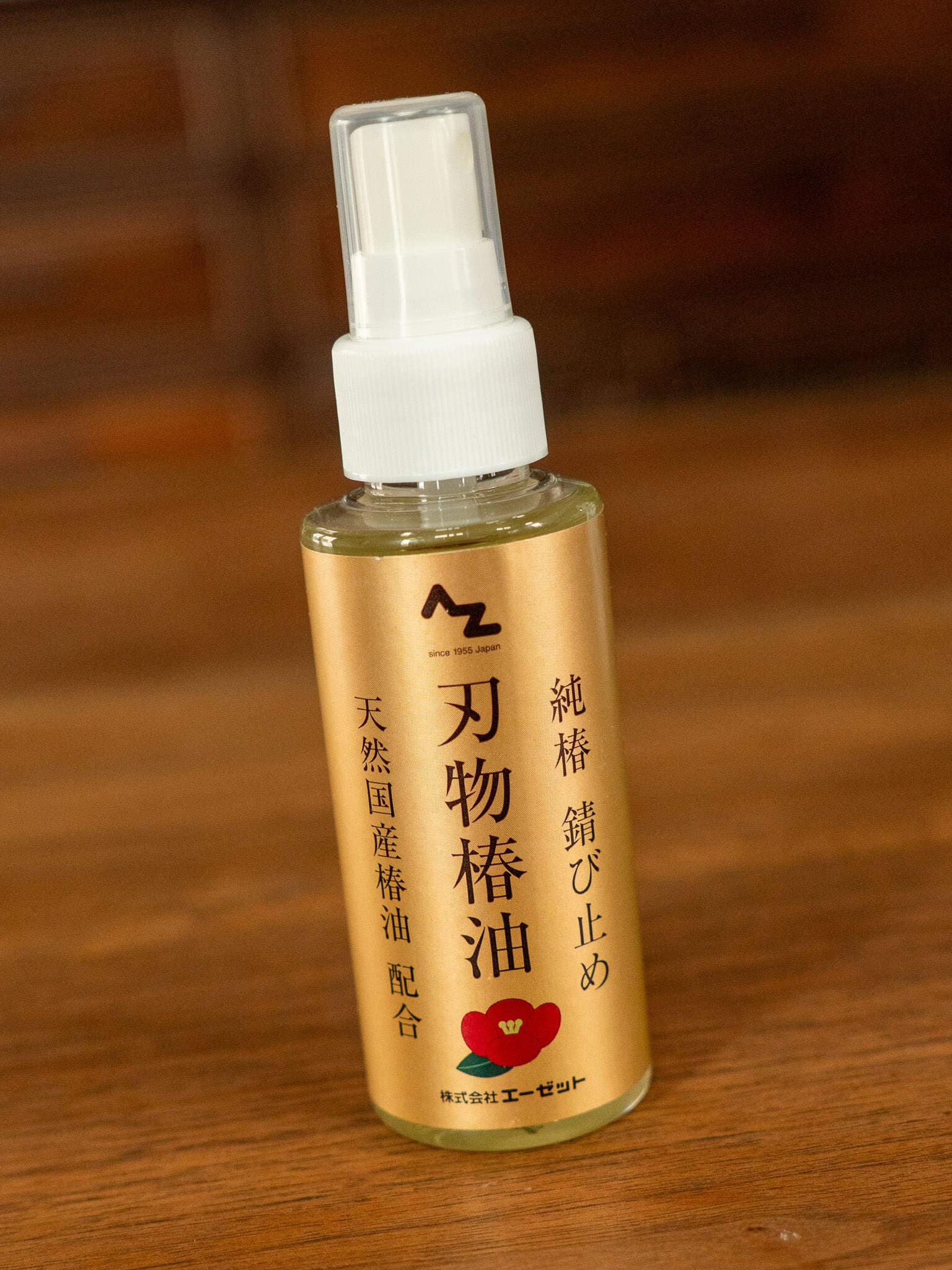 Bottle of Japanese knife oil with a spray nozzle on a wooden surface