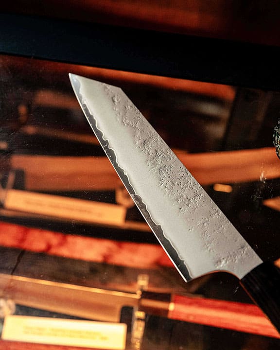 Close-up of a chef's knife with a blurred background