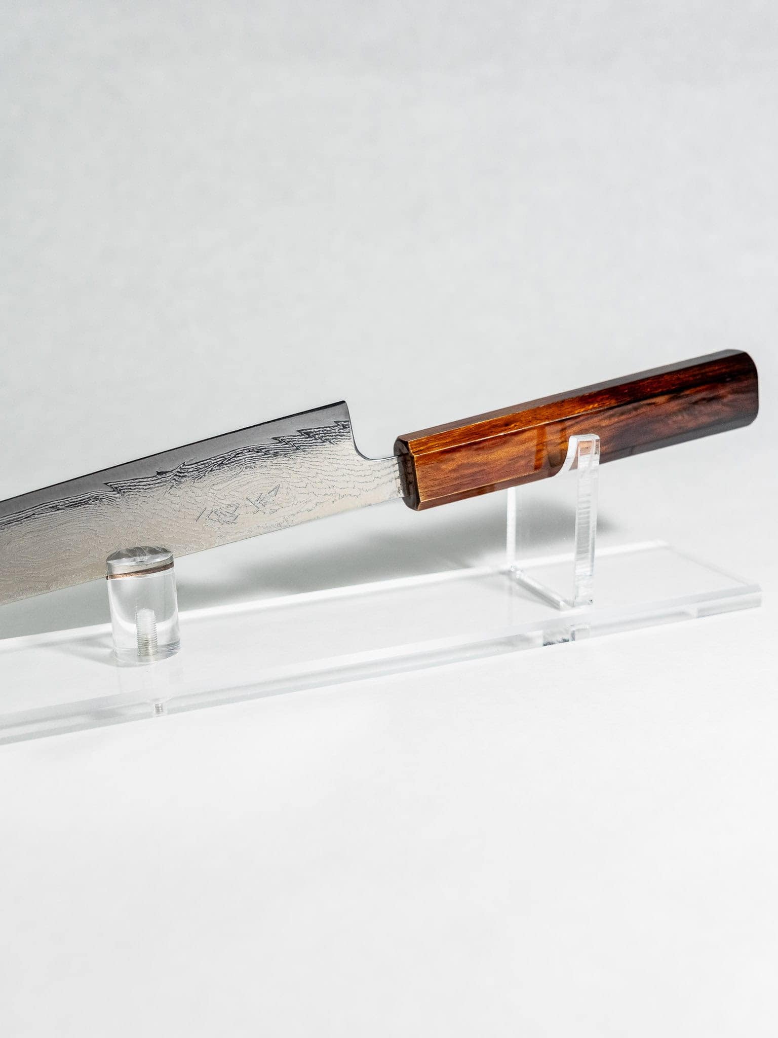 AUS-10A stainless steel Damascus patterning and hammered OUL maker's mark close-up. 