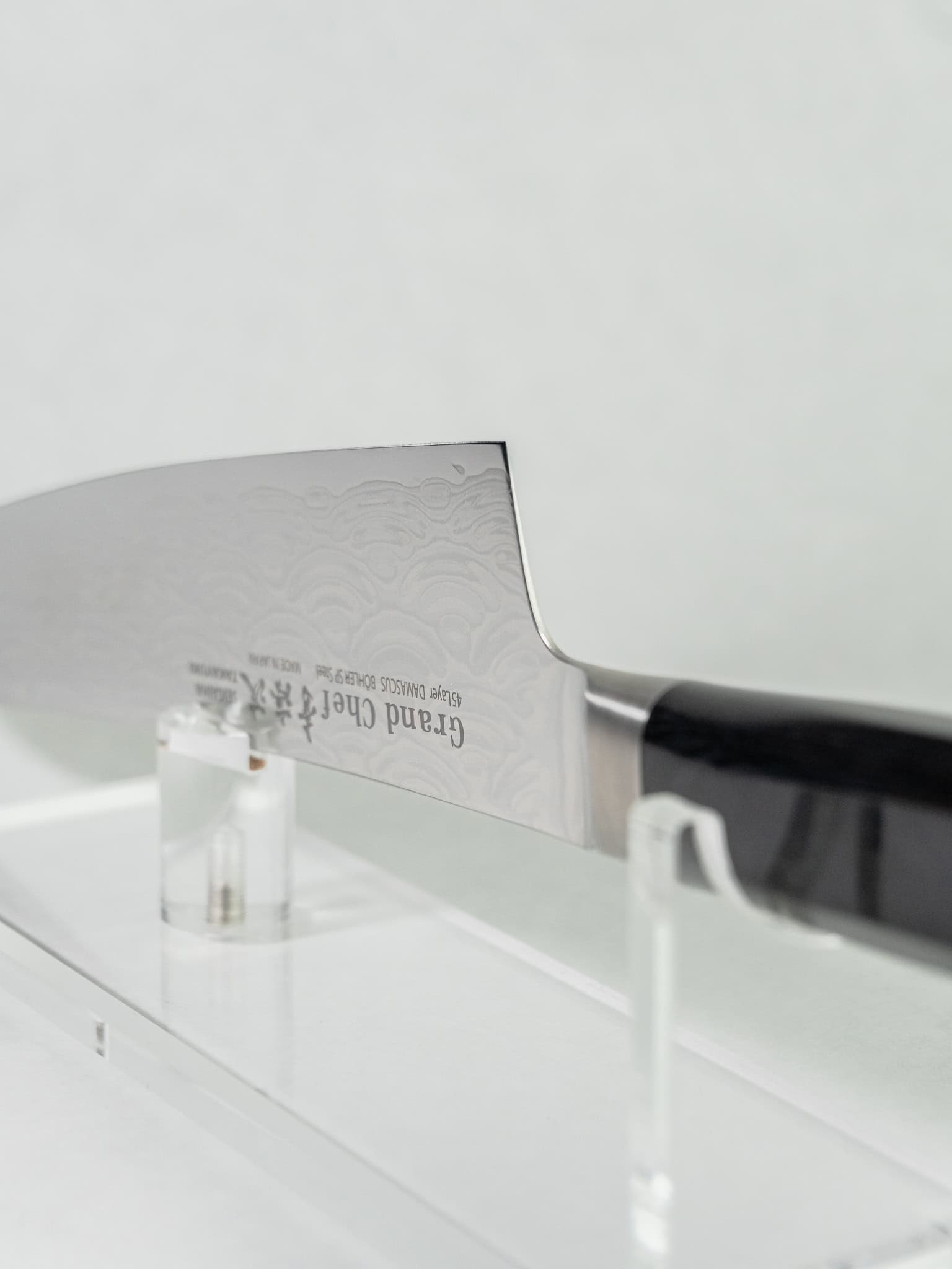 Close-up of a gyuto knife with 'Grand Chef' branding on a white background.