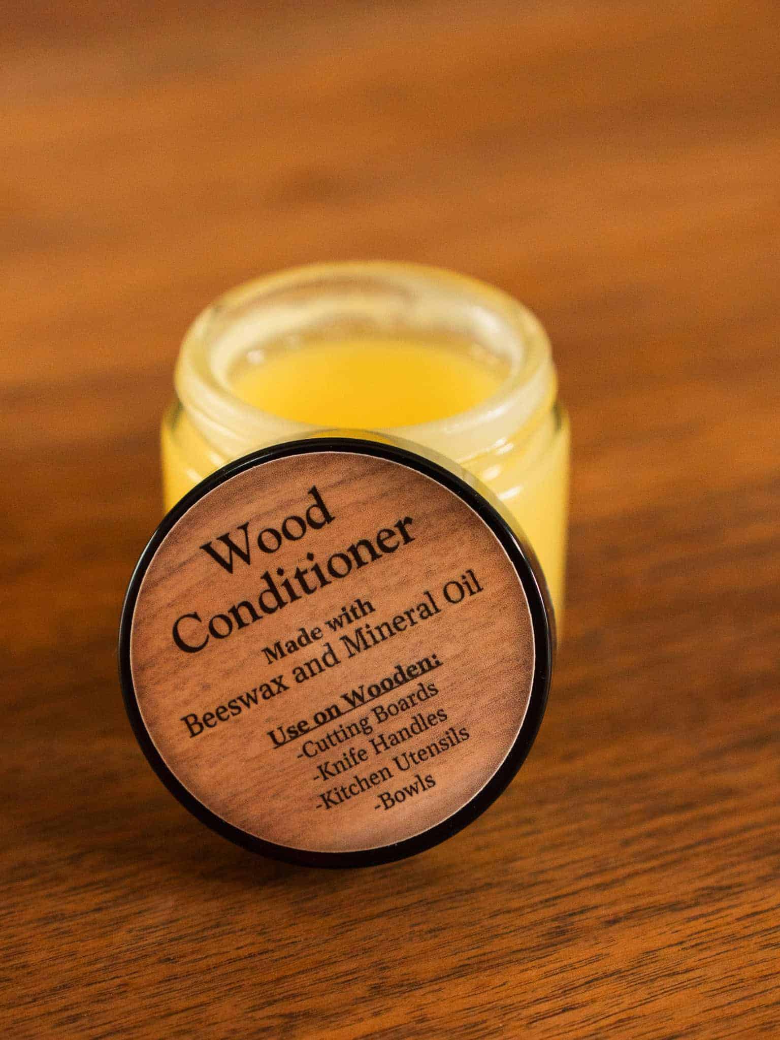 Jar of wood conditioner with wooden label on a wooden surface