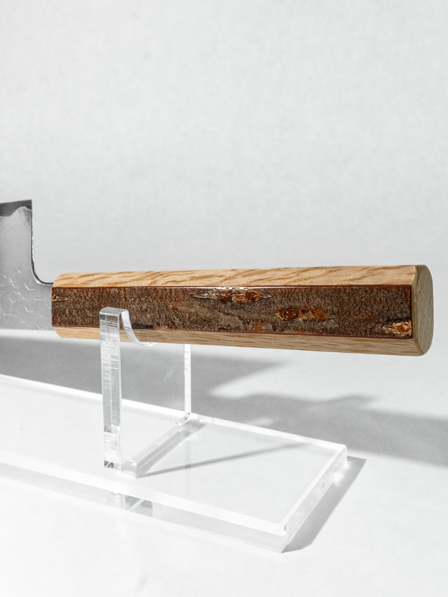 Close up of the oak and lacquered cherry bark handle on HADO bunka knife. Nice contrast with the dark cherry on the light oak wood.
