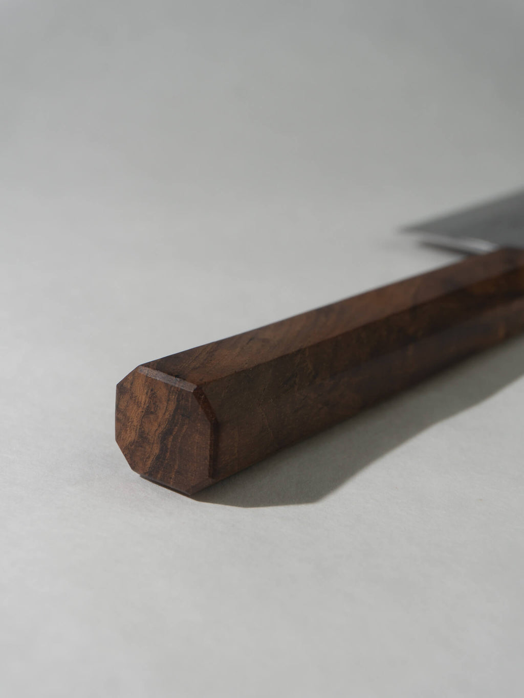Octagonal Jati wood handle of Nakiri knife, highlighting ergonomic design.