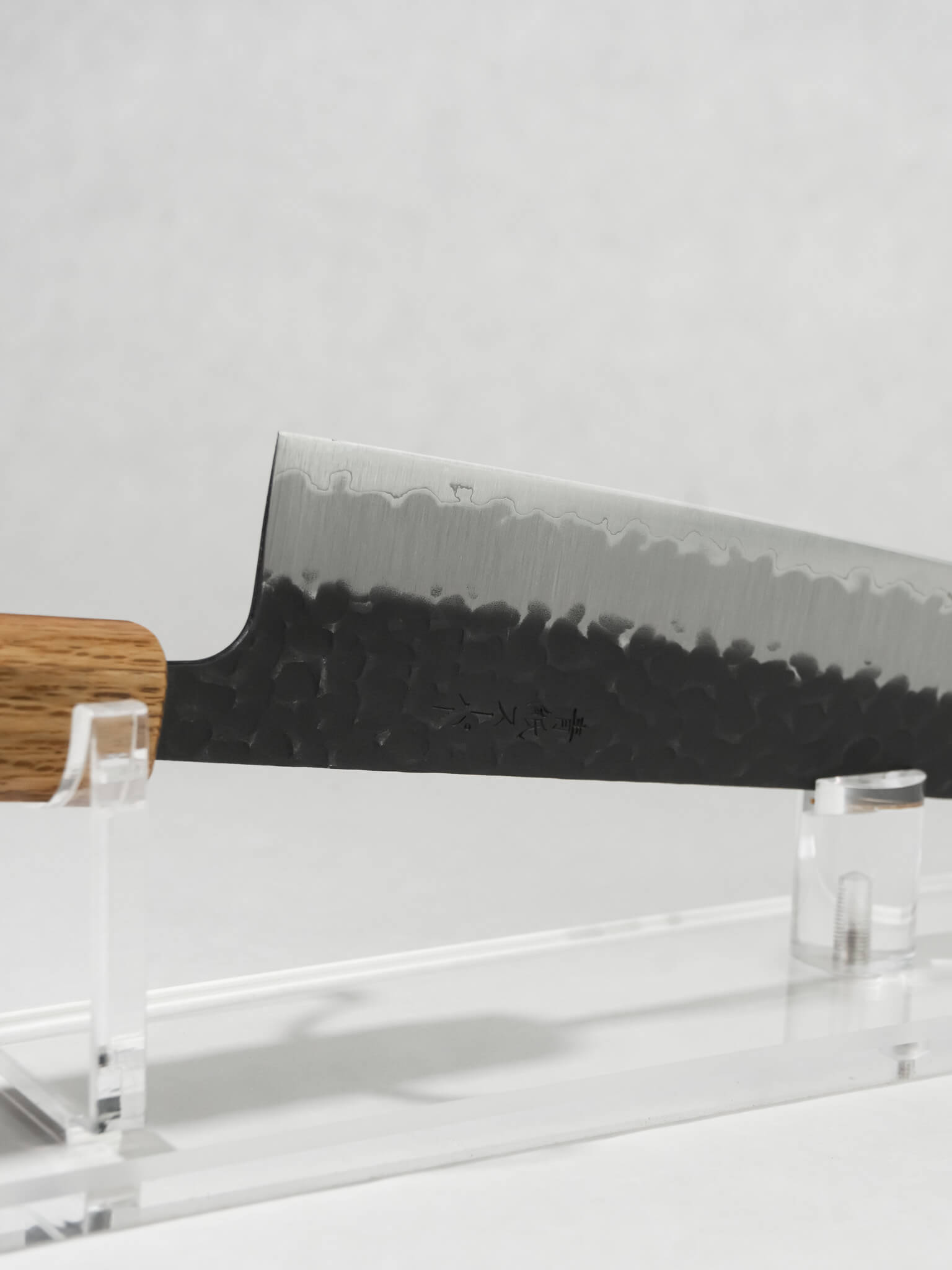 Side profile of OUL 210mm Gyuto knife showing full kurouchi tsuchime blade and octagonal darkened oak handle.