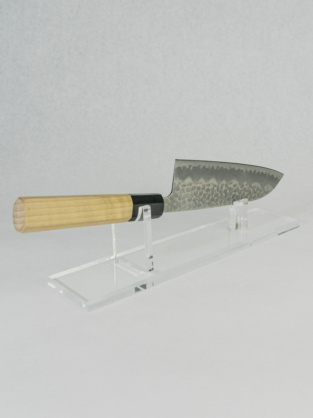 Side profile of OUL 180mm Santoku showing compact proportions and broad blade shape for efficient cutting.