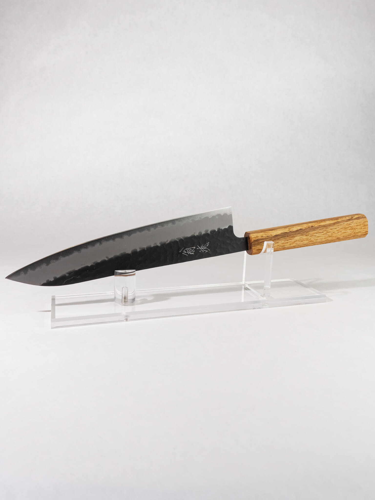 OUL 210mm Gyuto knife with Aogami Super steel core, hand-hammered tsuchime and kurouchi finish, octagonal darkened oak handle.