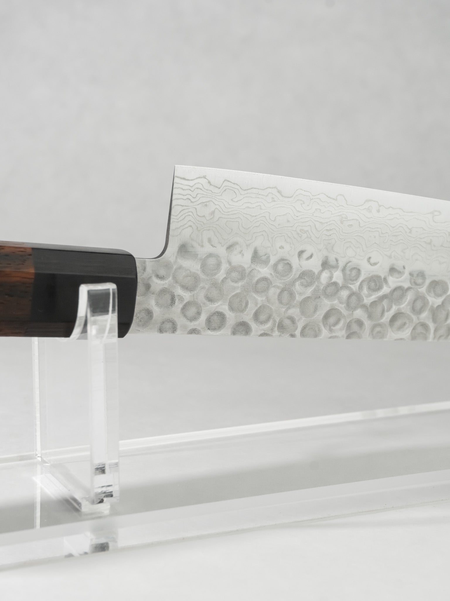Close-up of AUS-10A Gyuto blade featuring stainless Damascus tsuchime finish.