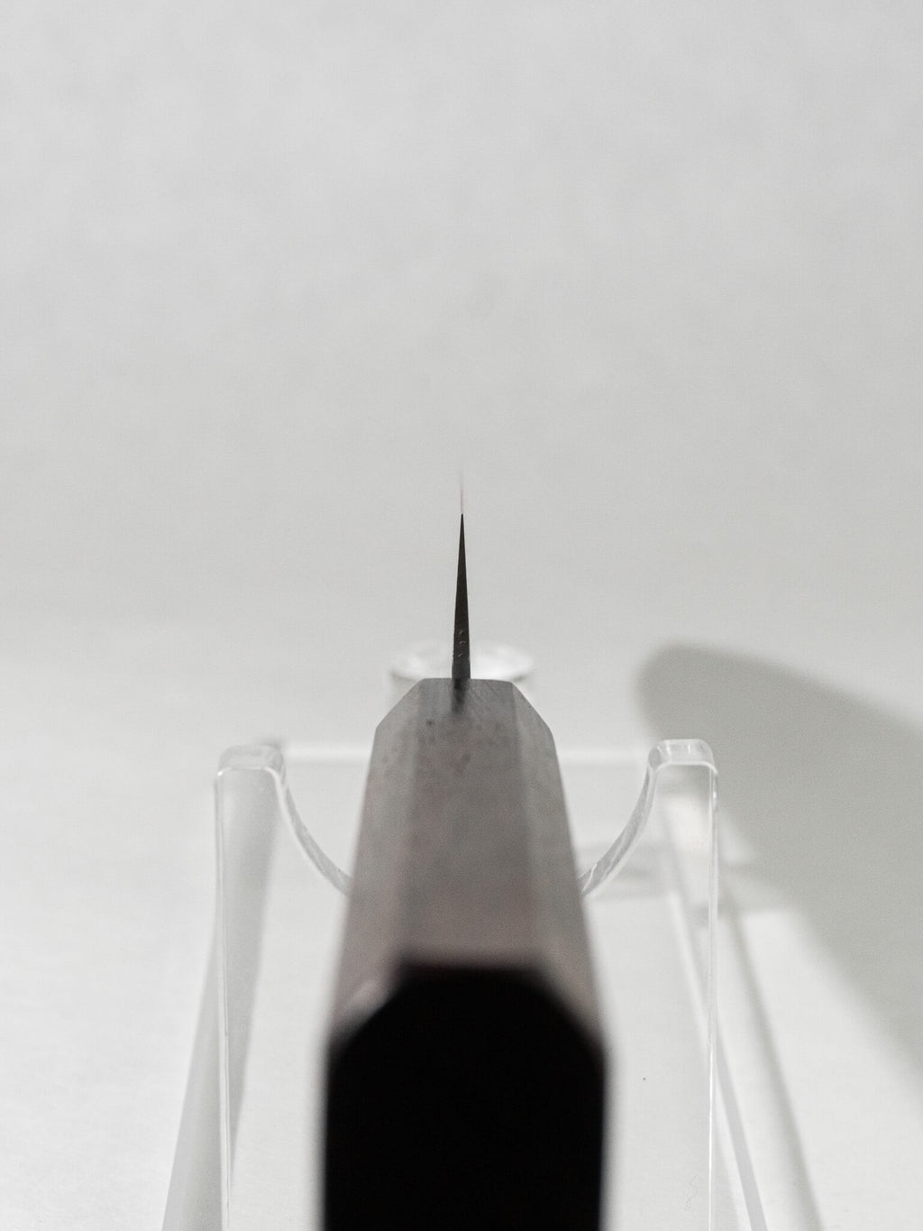 Close-up of the OUL Damascus Tsuchime Sujihiki knife choil, showcasing the precise craftsmanship and functional design for safe and controlled cutting.