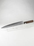 OUL Damascus Tsuchime Sujihiki or slicer knife with a long, slender blade ideal for precision slicing of fish, meat, and roasts. Features a hammered (tsuchime) finish for reduced food sticking and a beautiful layered Damascus pattern. Paired with a comfortable handle for balance and control, perfect for professional chefs and home cooking enthusiasts.