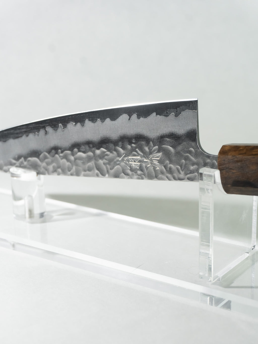 Close-up of OUL Gyuto blade showing White #1 steel core and stainless tsuchime finish.