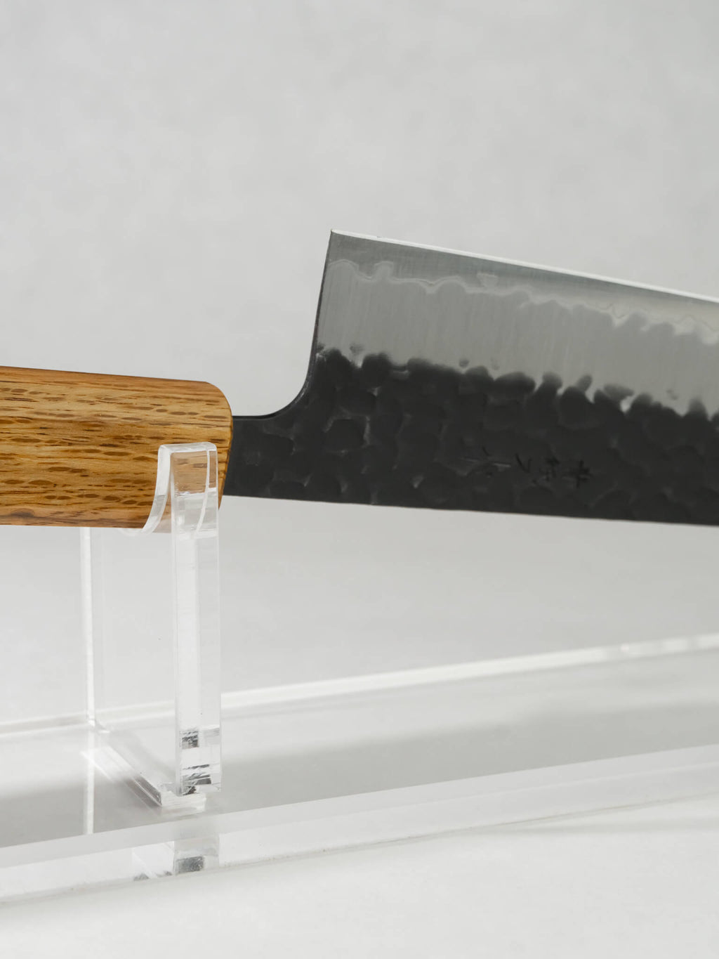 Detail of OUL Aogami Super Gyuto kurouchi blacksmith finish enhancing food release.