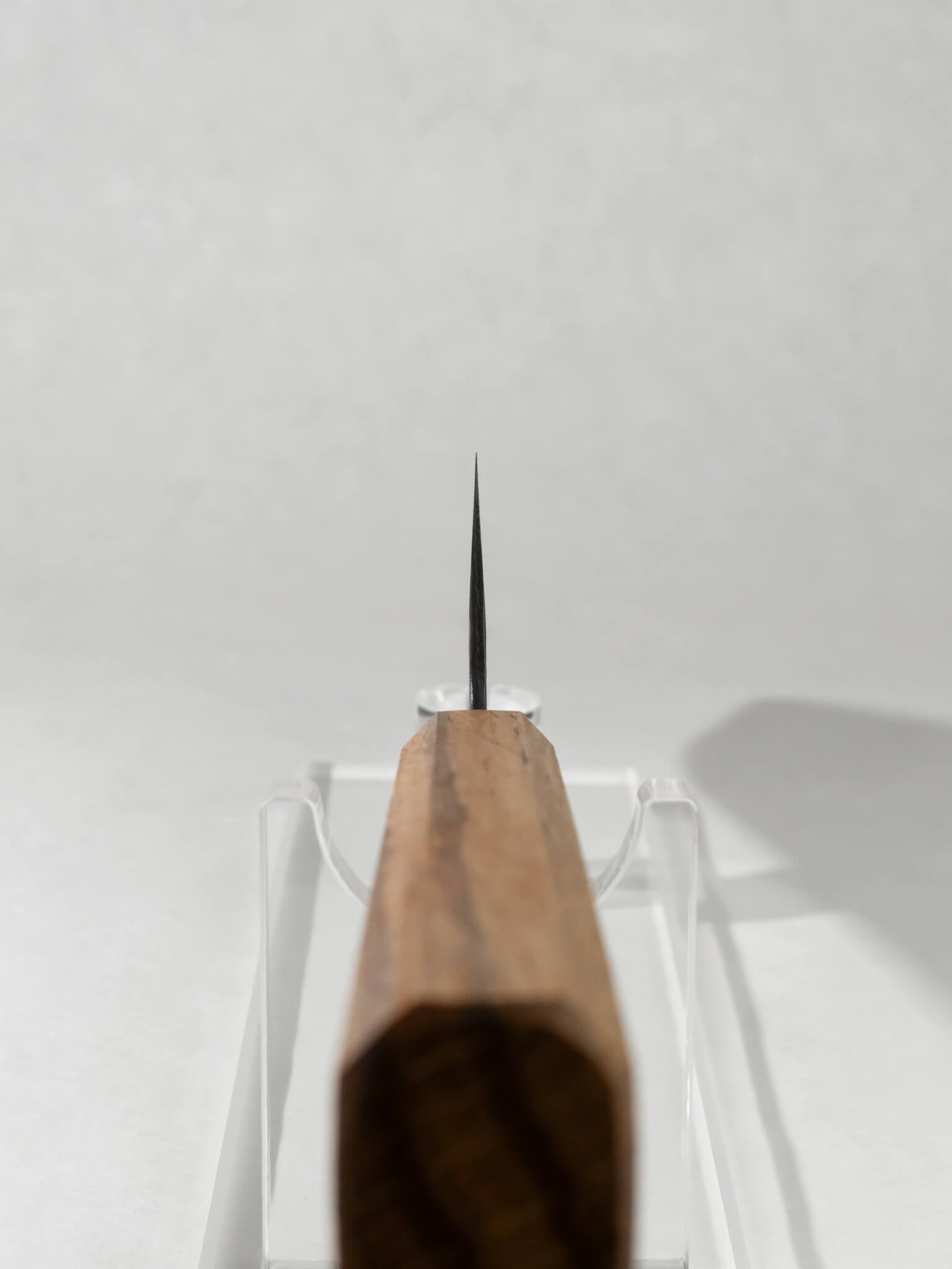 Close-up of OUL Gyuto choil and blade geometry showing craftsmanship and precision. Detail of handle with ergonomic design and polished ferrule.