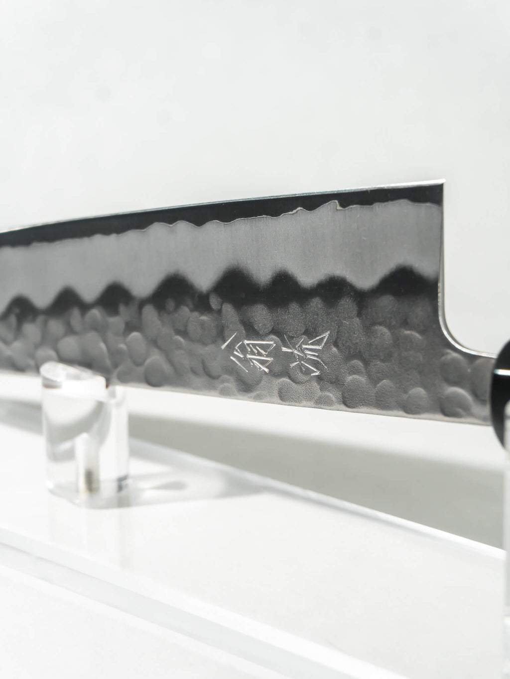 Close-up of OUL Gyuto blade showing White #2 core and stainless tsuchime or hammered finish.