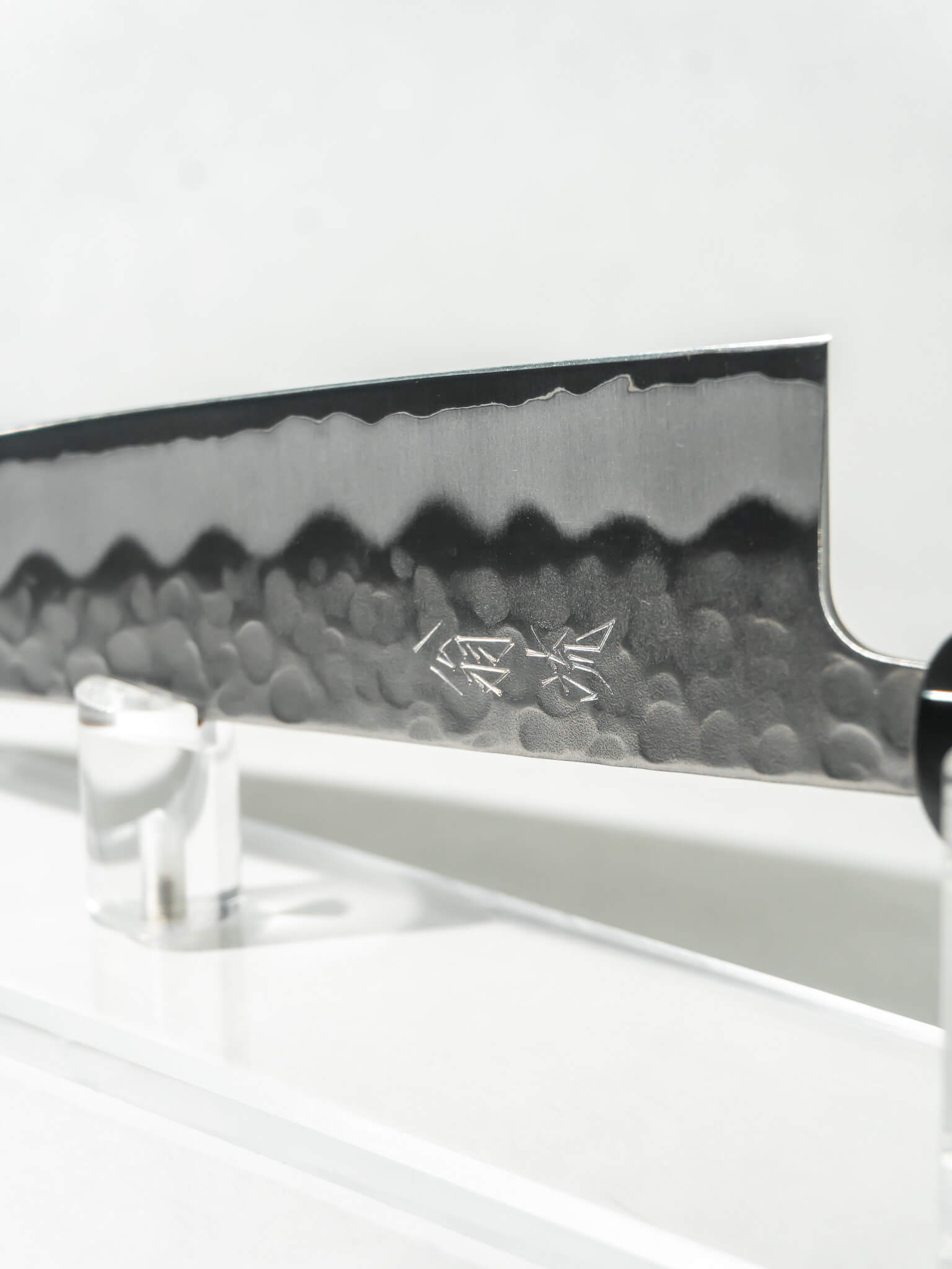 Close-up of OUL Gyuto blade showing White #2 core and stainless tsuchime or hammered finish.