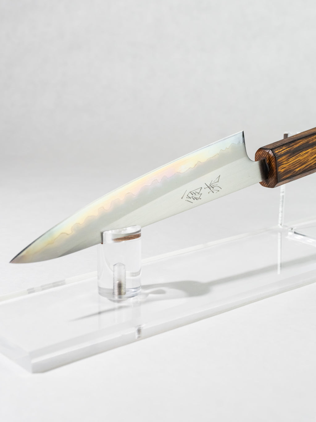 Side profile of OUL 135mm petty knife, showing the full side of the blade, highlighting the gentle, almost  iridescent kasumi.