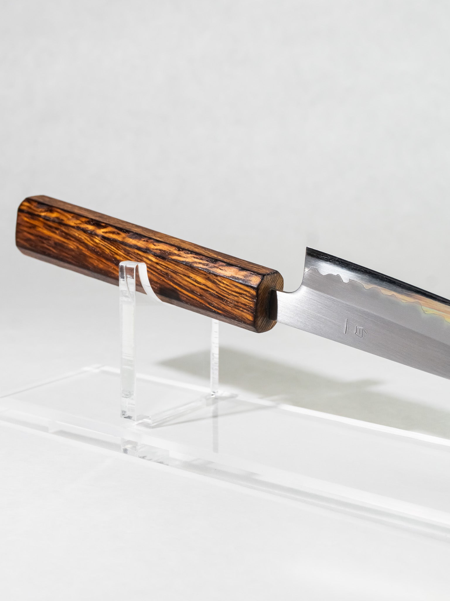 Close-up of octagonal darkened oak handle on OUL 135mm petty knife for ergonomic, balanced grip.