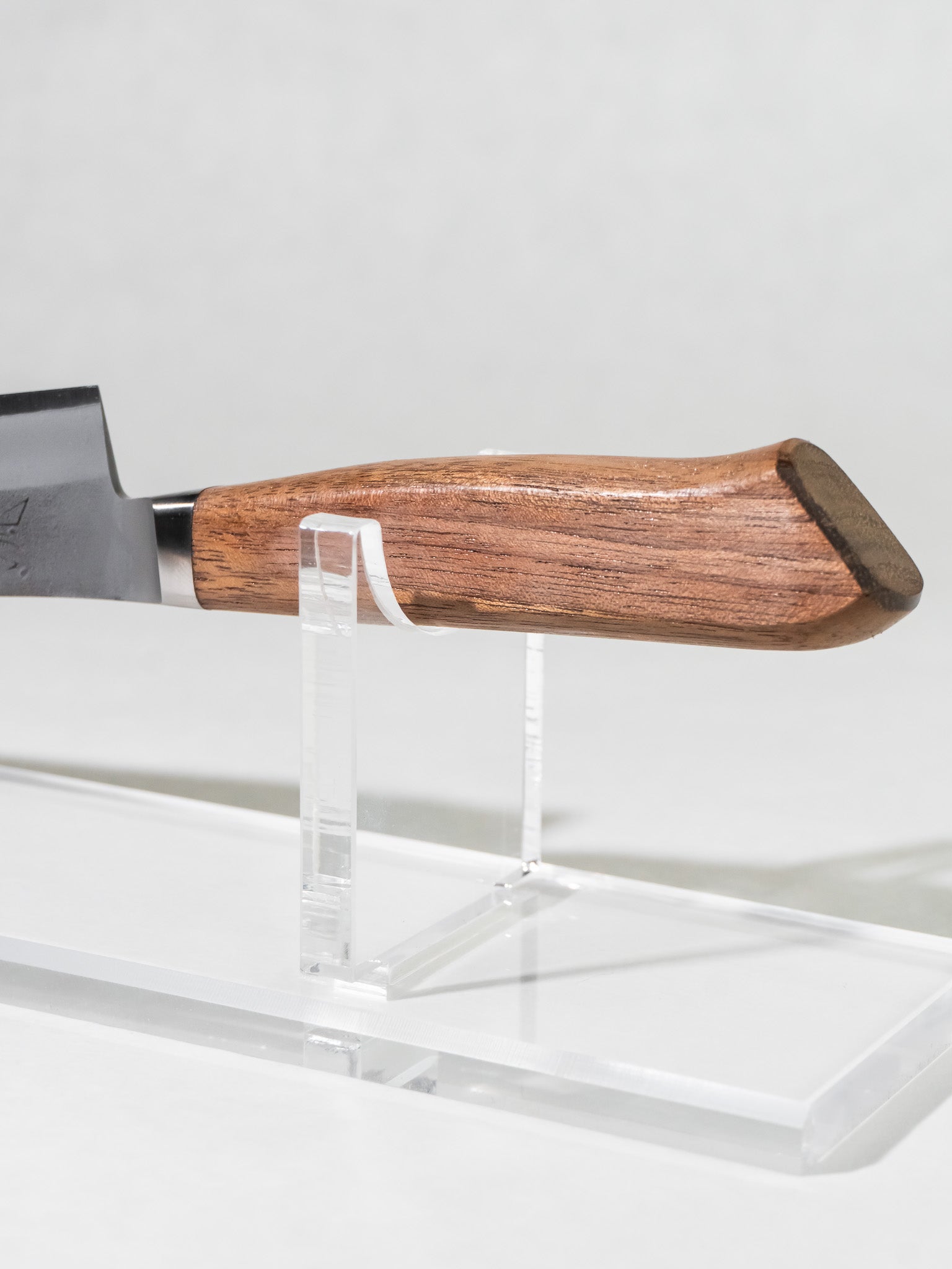 Close-up of the OUL petty knife handle, crafted from Western walnut with an integrated bolster for ergonomic balance and comfortable grip.