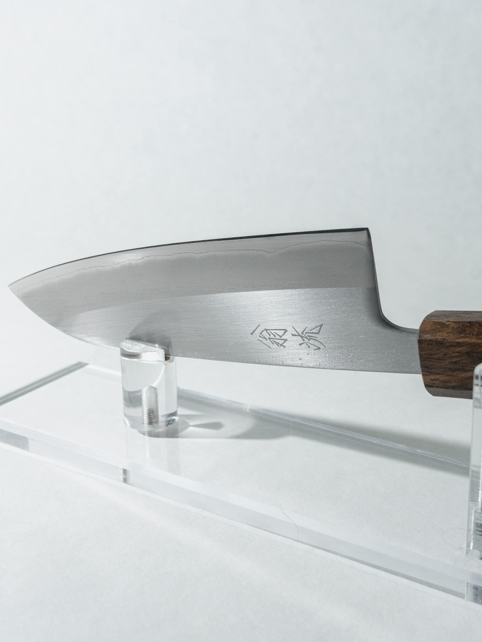 Close-up of the OUL Santoku blade showing kasumi finish and high-carbon White #1 core.