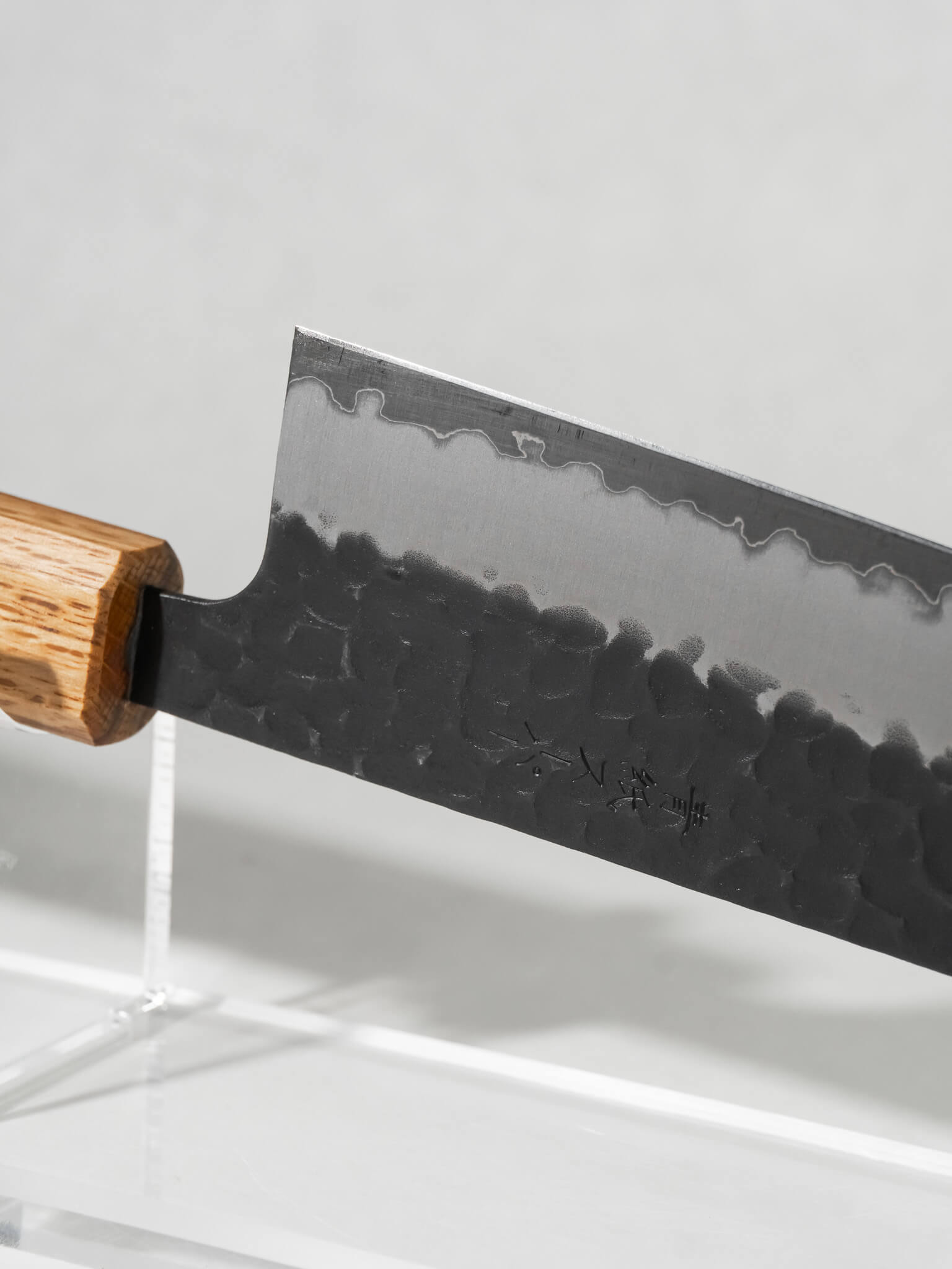 Angled view of OUL Aogami Super Gyuto highlighting balance, thin edge, and traditional Japanese craftsmanship.