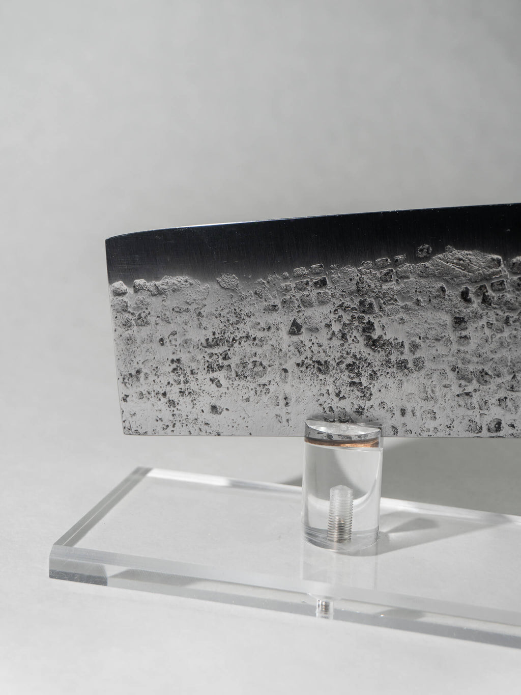 Close-up of sustainable recycled leaf spring Nakiri knife showing hammered tsuchime pattern, small square textures, and sharp square tip for precise vegetable slicing.
