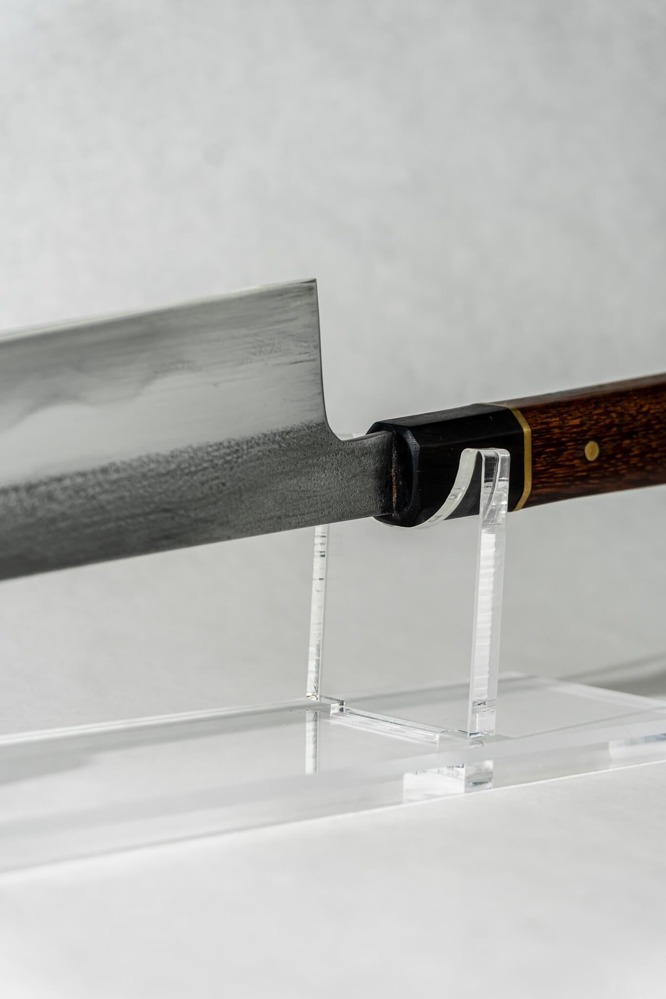 Close-up of where the choil meets the octagonal red rengas handle with brass spacer and rosewood ferrule.