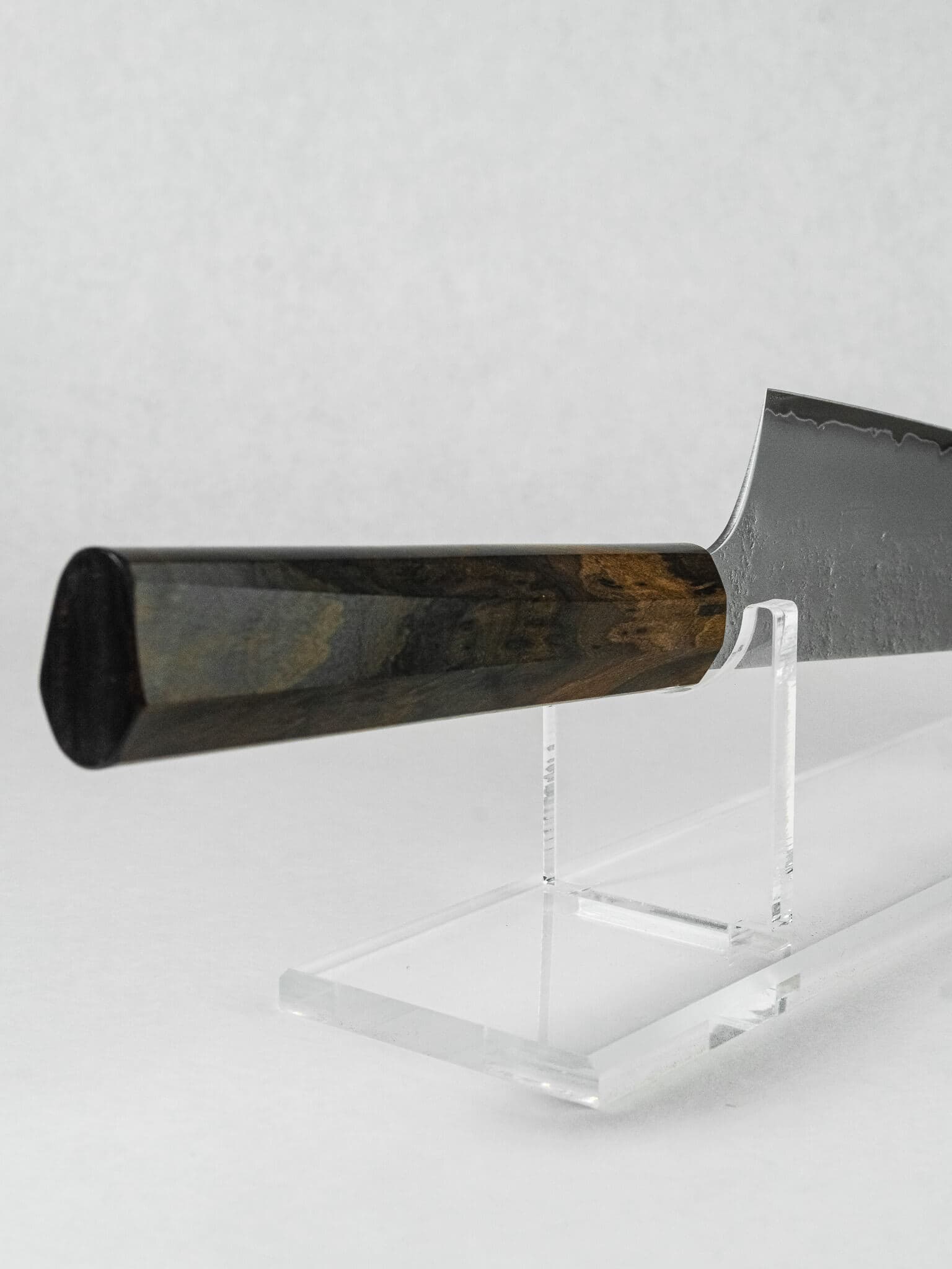 Close up of the hybrid octagonal ebony handle on Sakai Takayuki Kengata knife, designed for comfort and sleekness.
