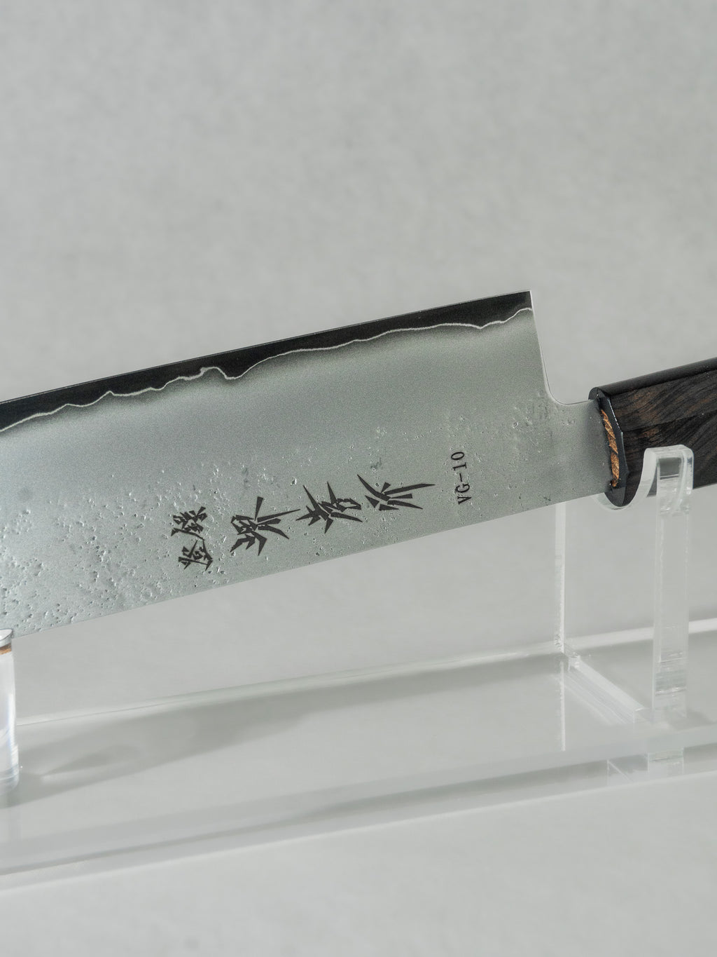 Close up of Sakai Takayuki nakiri knife featuring their printed logo on the side of the VG-10 steel blade. 
