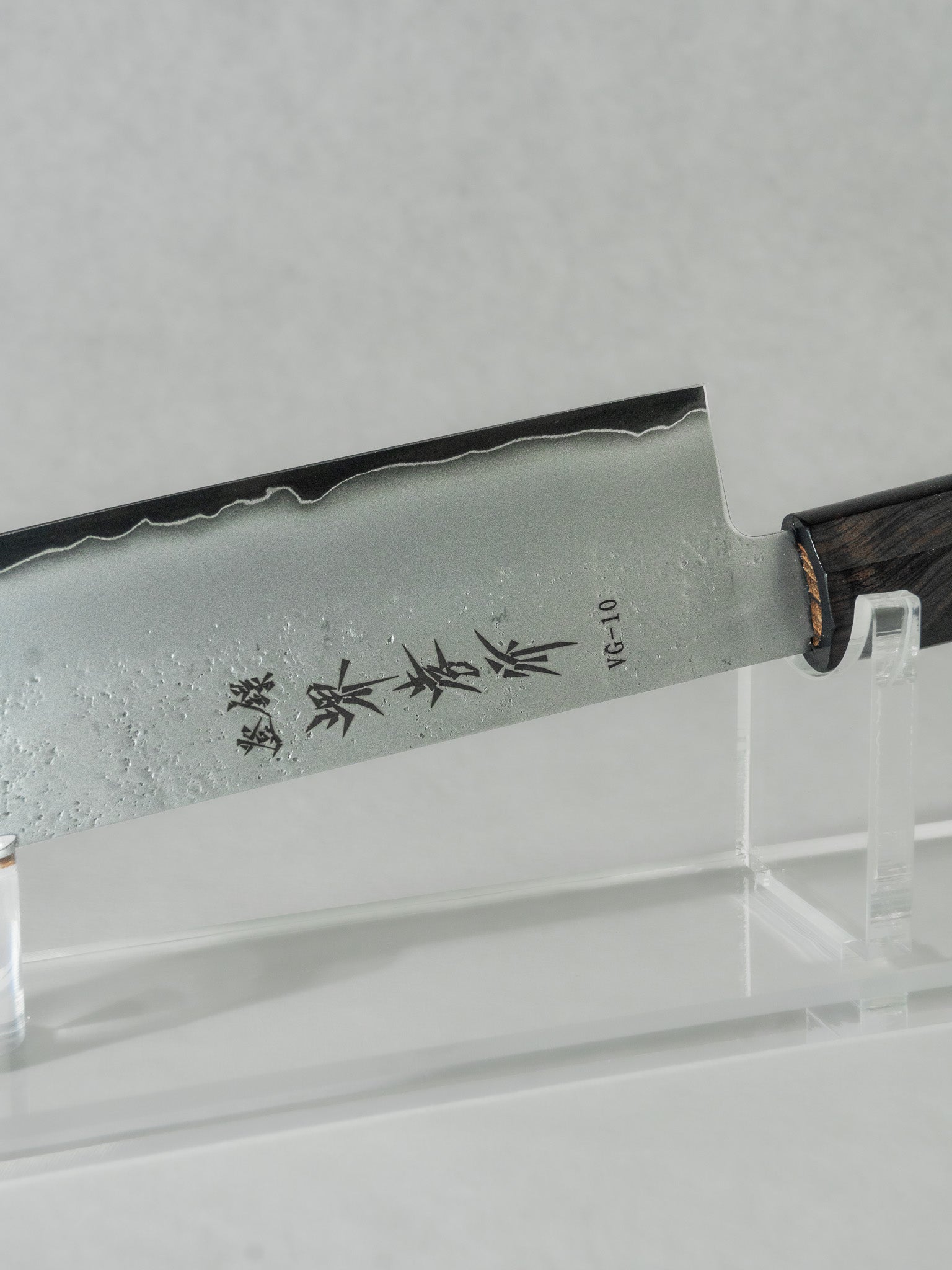 Close up of Sakai Takayuki nakiri knife featuring their printed logo on the side of the VG-10 steel blade. 