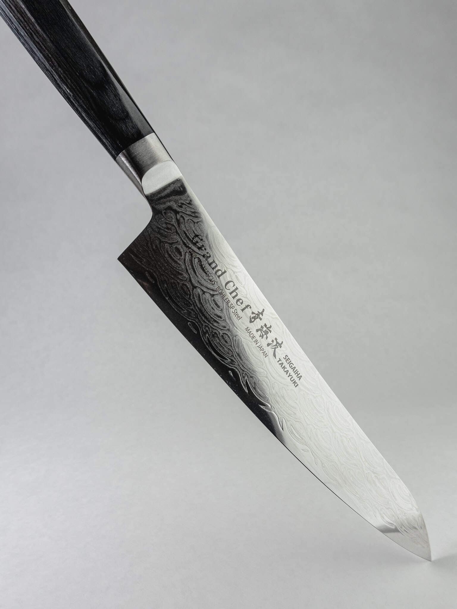 Stainless Damascus tsuchime cladding on Gyuto blade.
