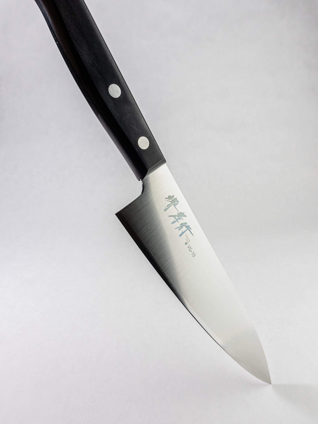 Sakai Takayuki knife made in Sakai City Japan. Full profile of the knife against a light grey background. 