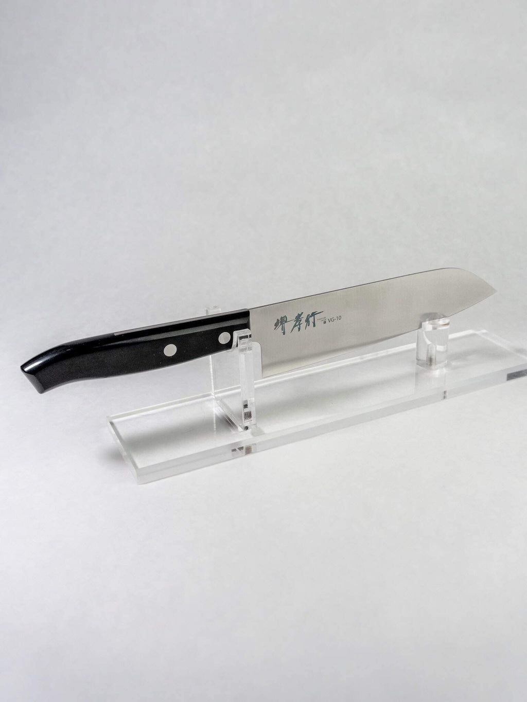 Sakai Takayuki Sumire Santoku 165mm Japanese kitchen knife on a clear stand.
