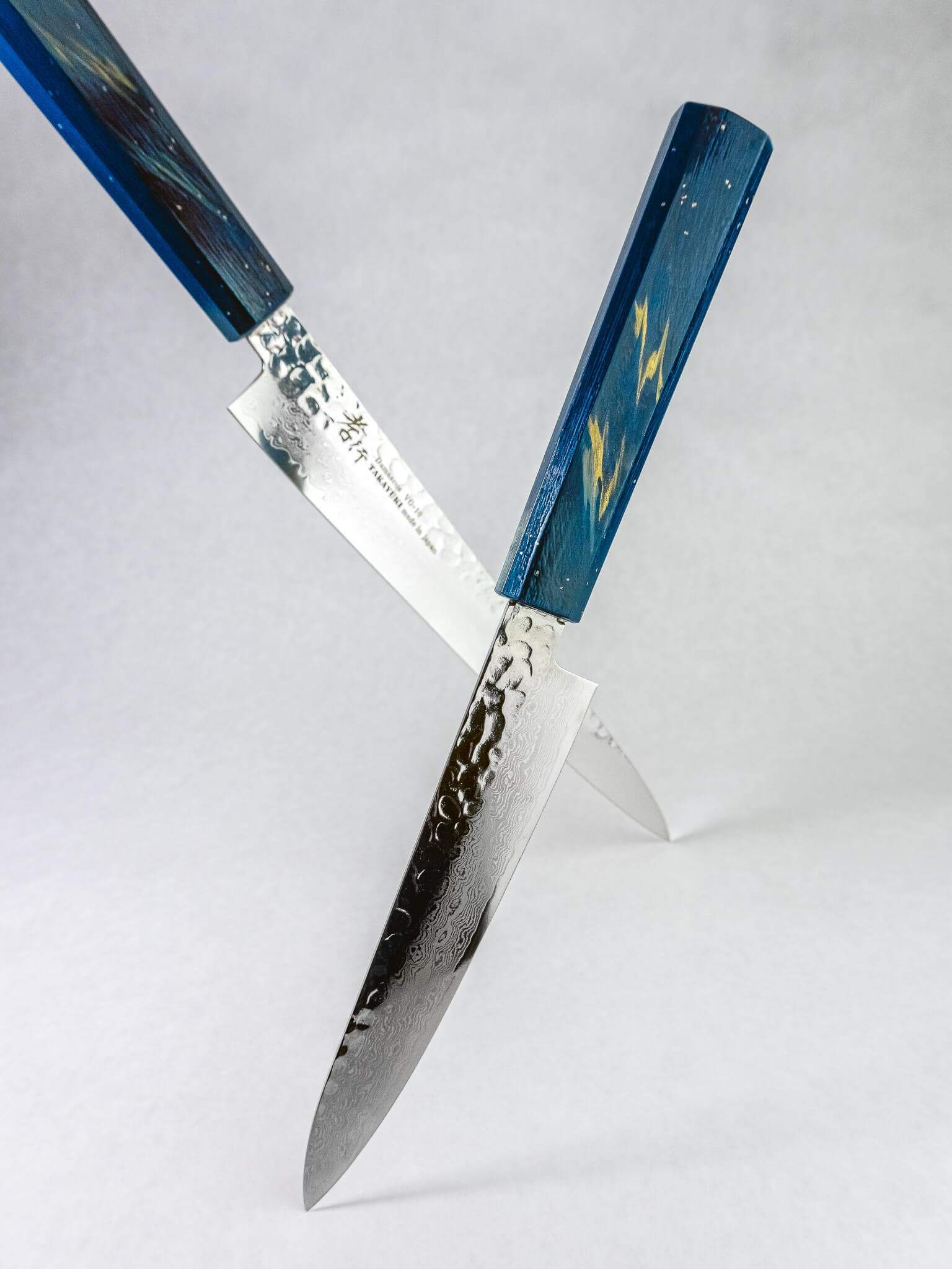 Saiseki petty knife displayed with it's gyuto counterpart. VG10 Damascus blade detail on Sakai Takayuki knives.