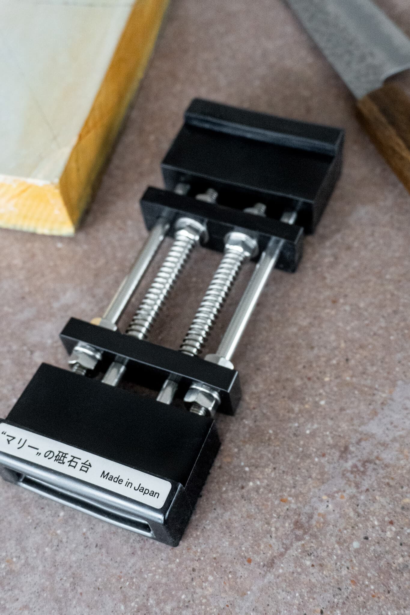 Rubberized resin base providing suction cup-like grip for sharpening stones