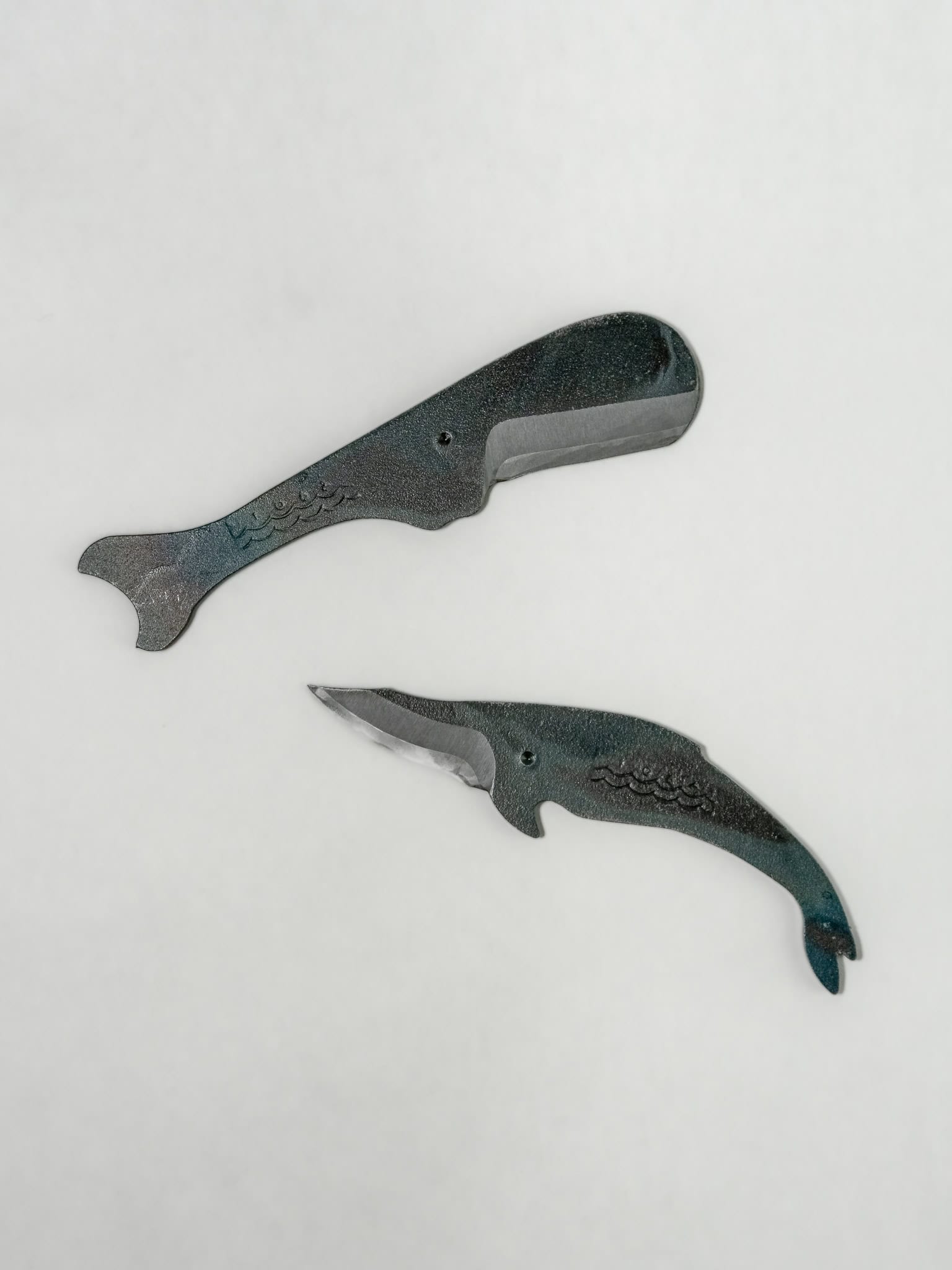 Two whale-shaped Japanese styled utility knife on a light gray background.