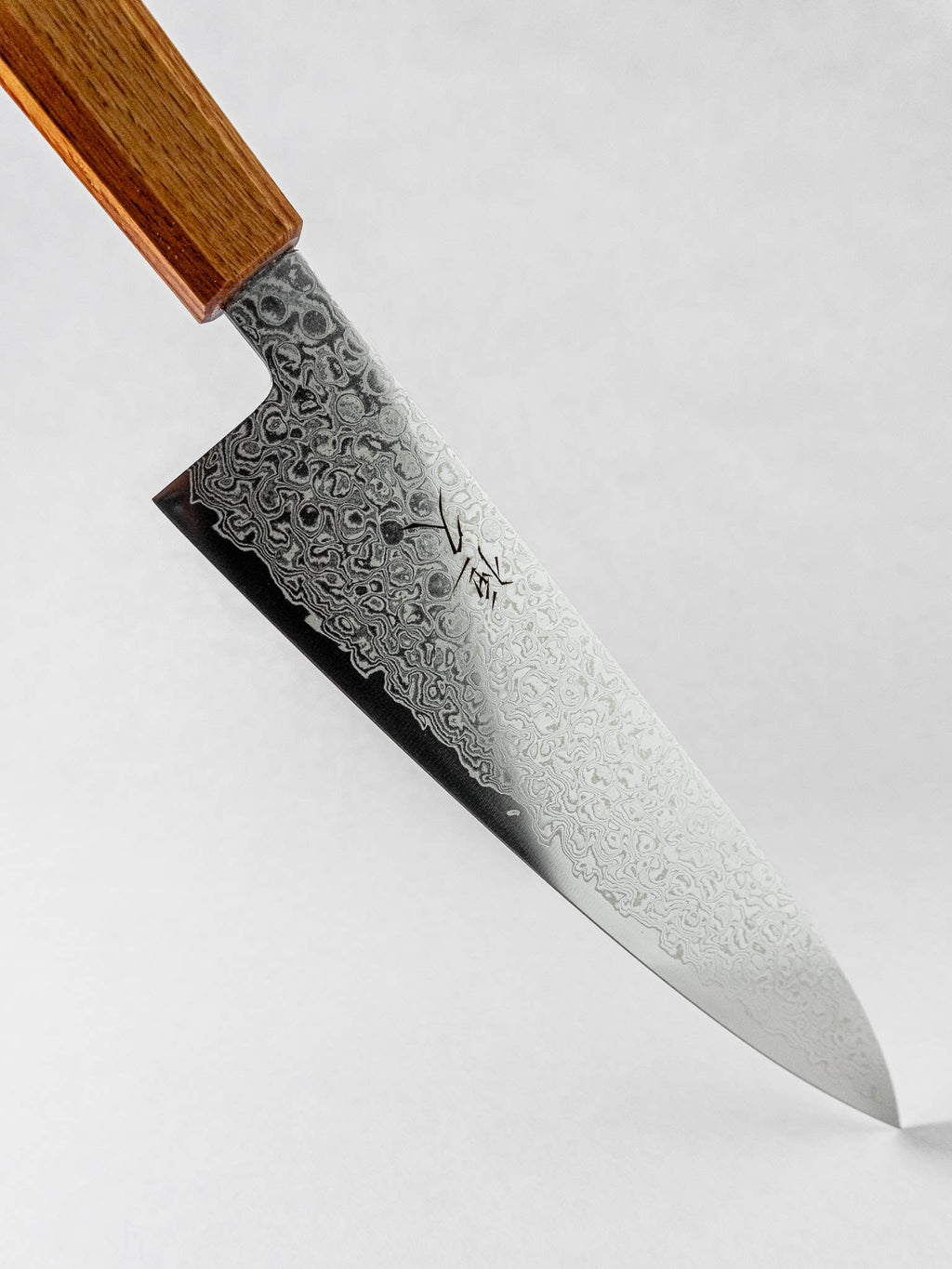 Stainless Damascus cladding pattern detail against a white background.